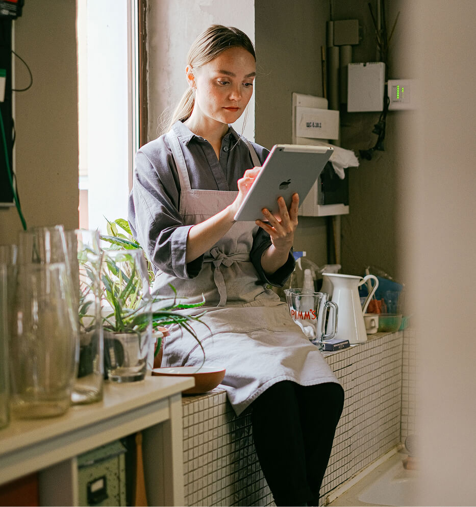 woman with apron reading ipad